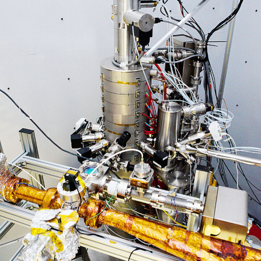 Photograph of the experimental setup showing the Nion UltraSTEM 100 microscope and attached vacuum pipes covered with kapton tape.